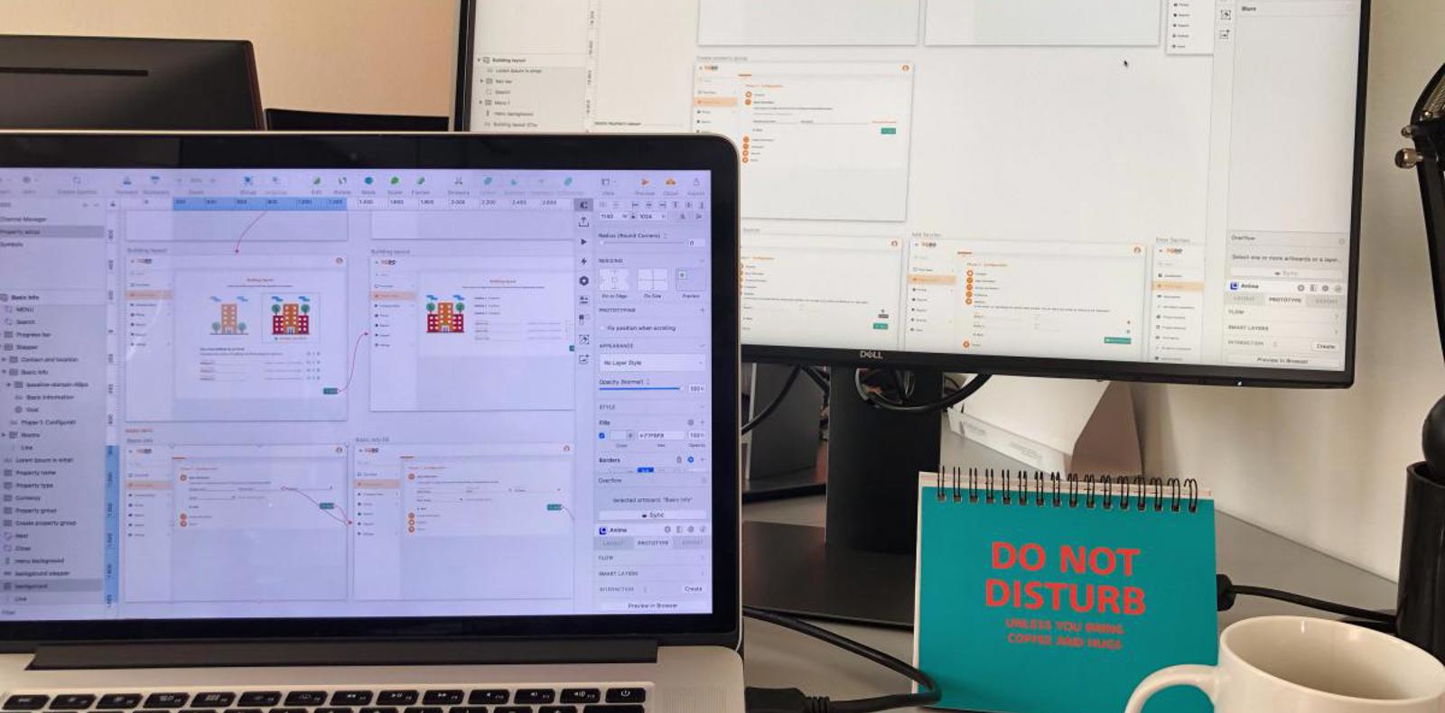 A desk of a designer displaying on their laptop prototypes.