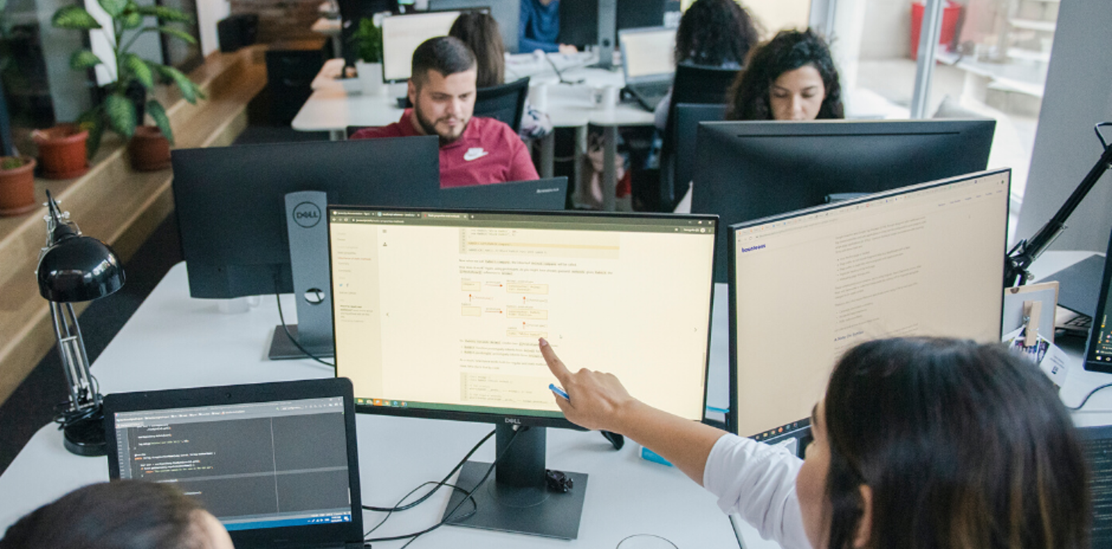 Employees working on computers in a modern office setting.