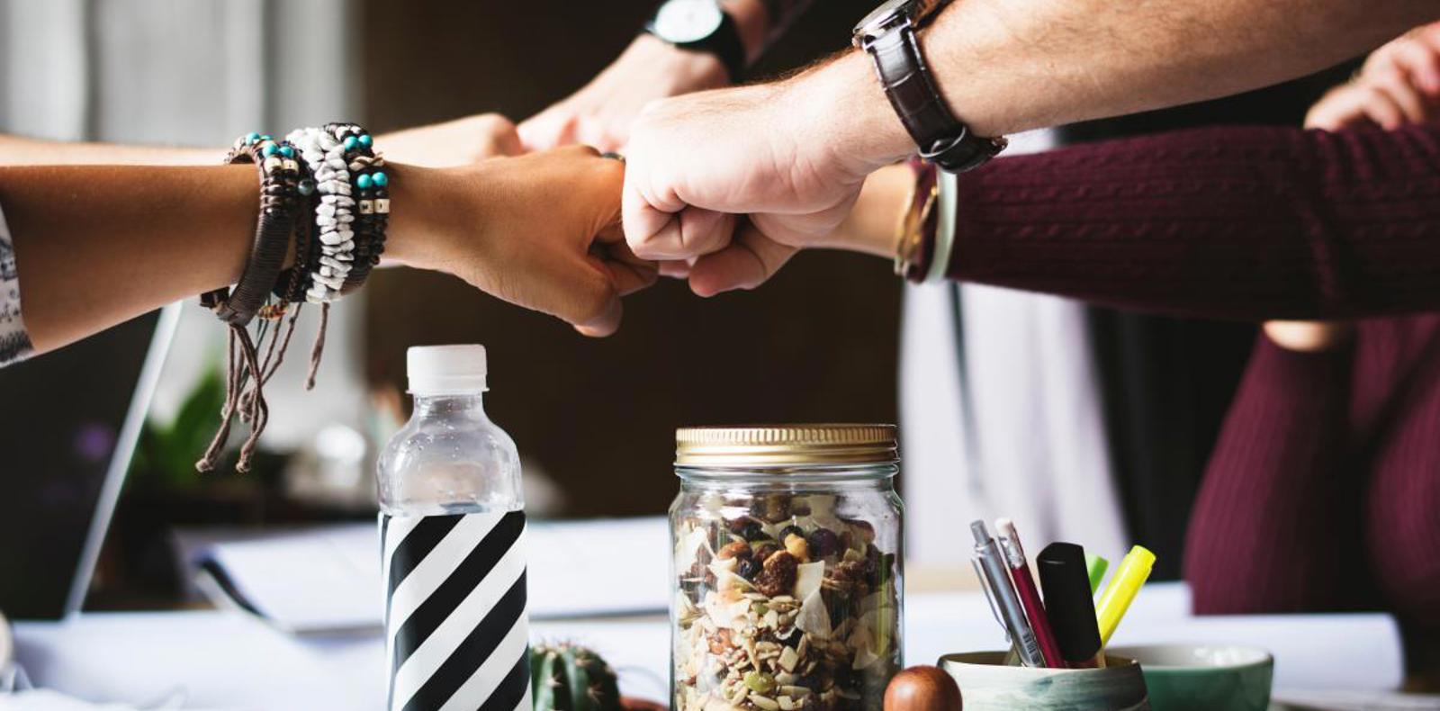 People doing a fist bump as a symbol of teamwork.