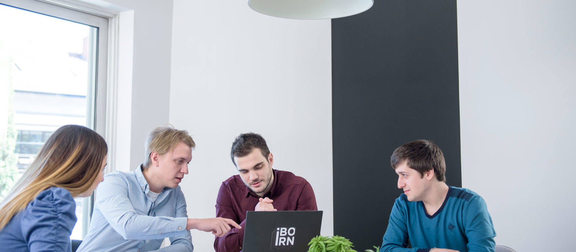 Three individuals collaborate in an office setting.