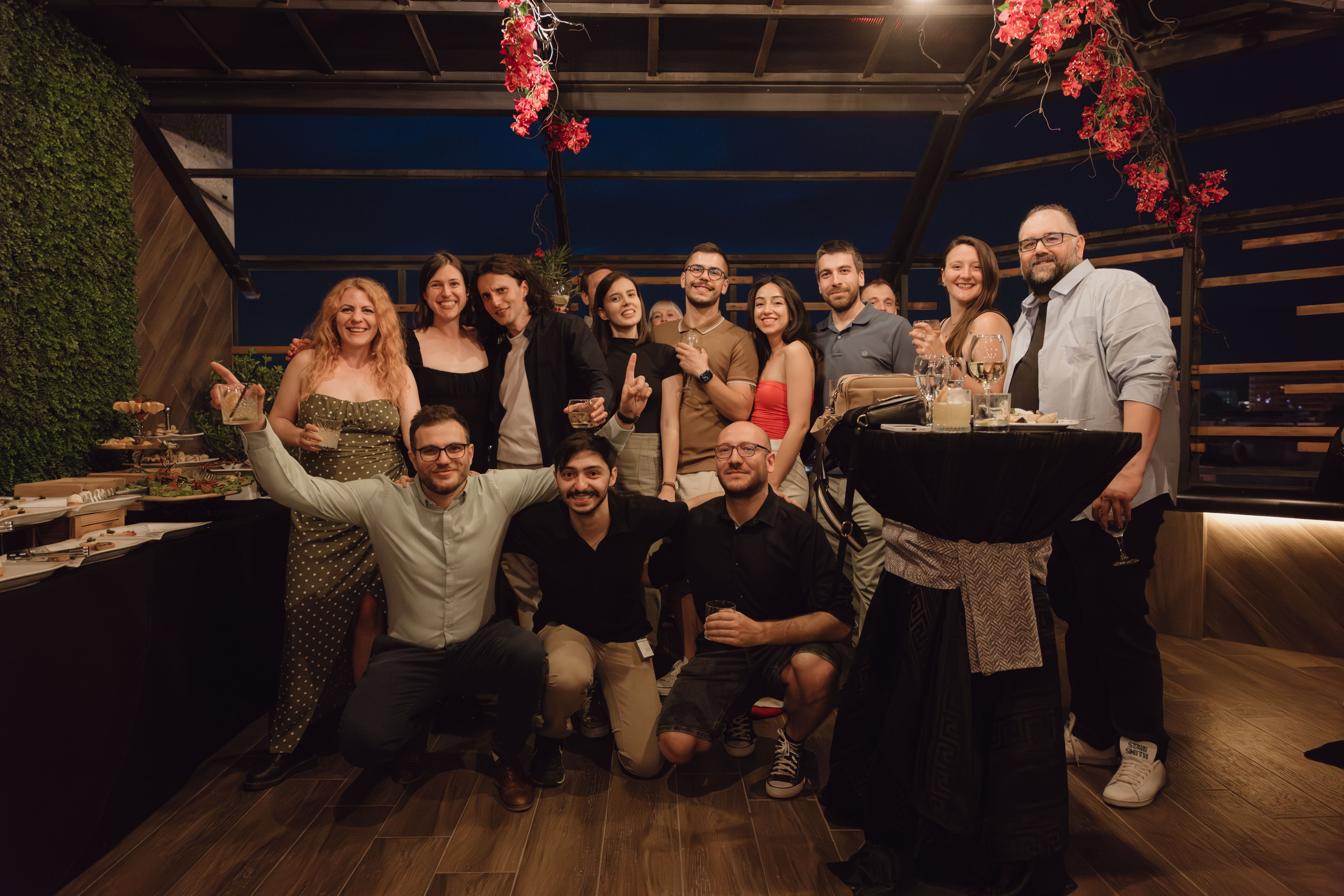 Smiling individuals gathered together for a group photo at a festive party.