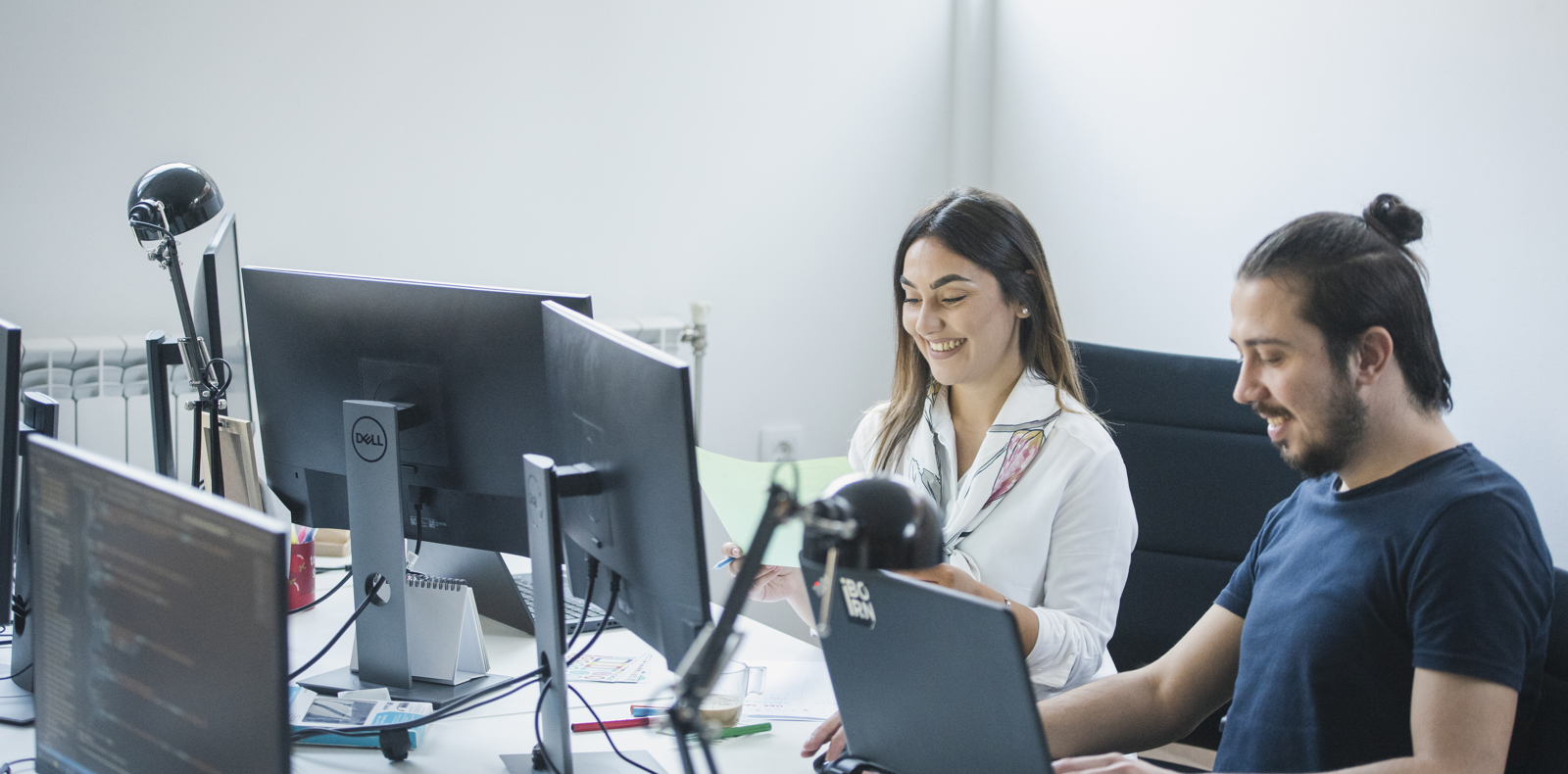 QA engineer and software engineer working together in a bright office environment. 