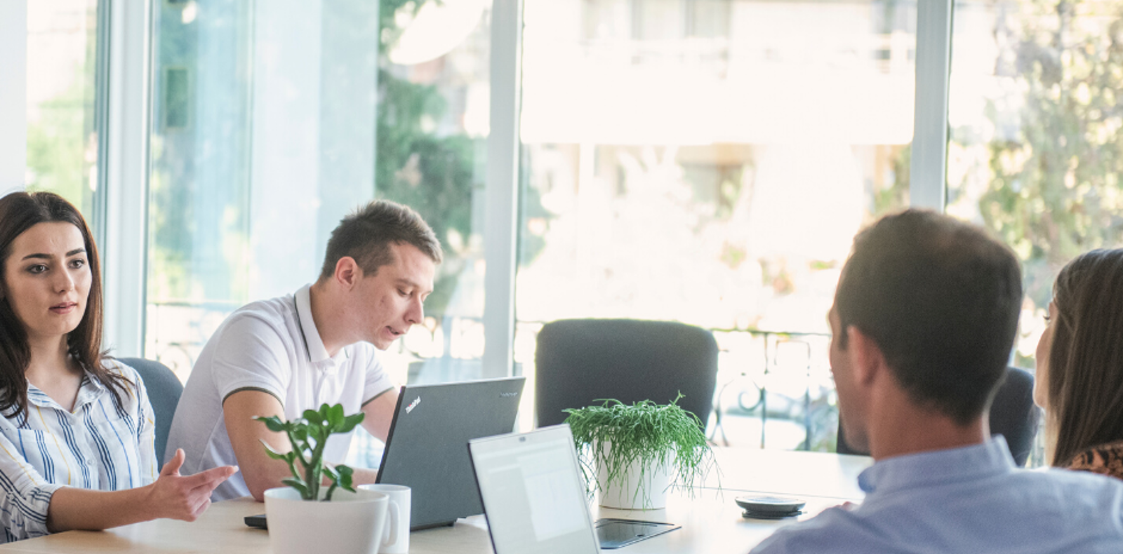 A group of software engineers sitting around a table with laptops, working together on a project.