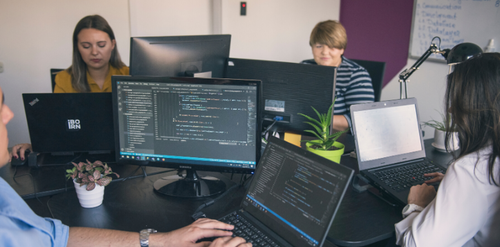 DevOps professionals diligently working on computers in a modern office setting.