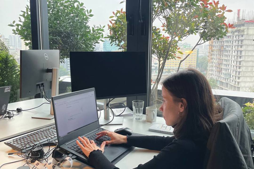 A woman sitting at a desk with a laptop, working on her tasks and staying productive.