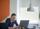 An individual seated at a desk, focused on using a laptop.