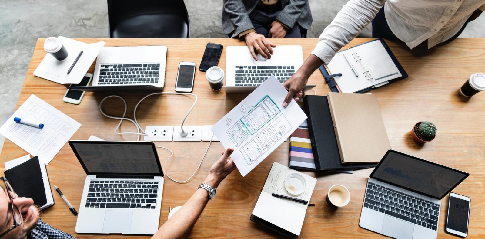 Group of professionals having a meeting with laptops.