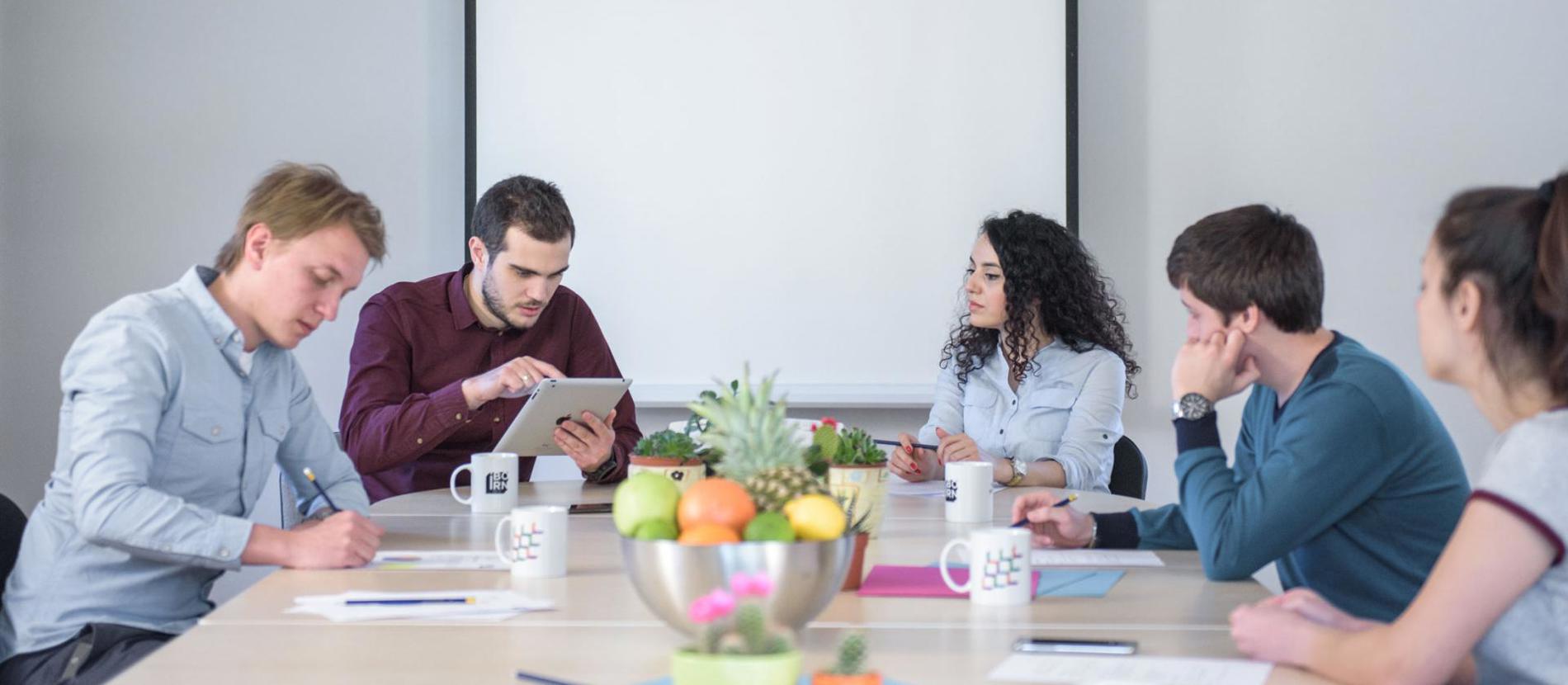 A  team of professionals diligently working on computers in a modern office setting.