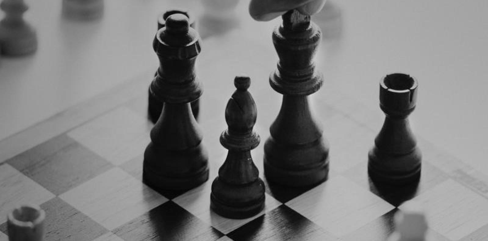 Black and white image of someone playing chess.