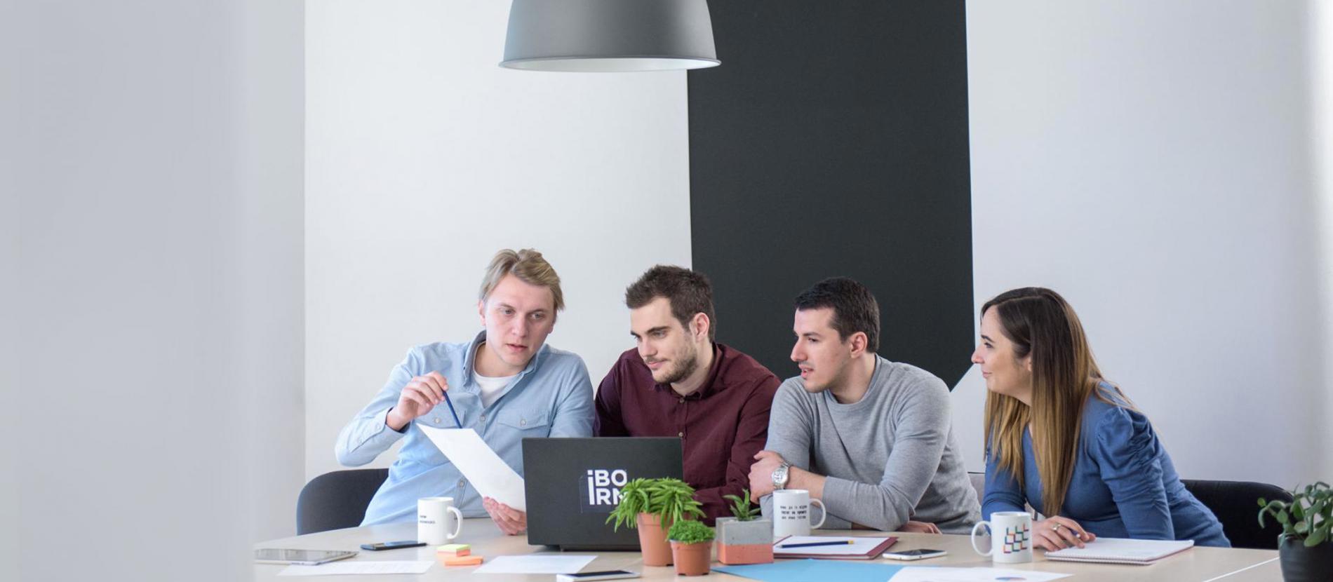 Team of people using laptops during a meeting.