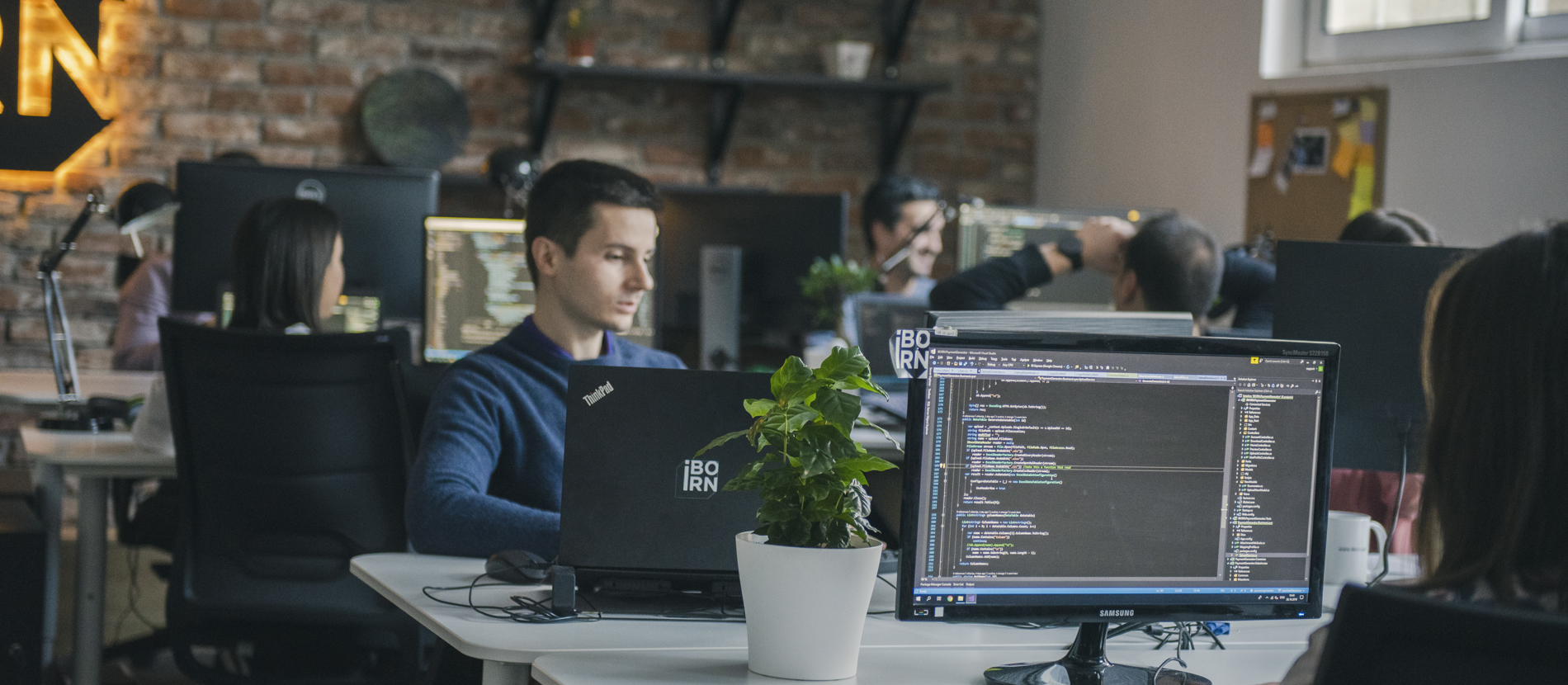 Software engineers working at their desks focused on computers and monitors. 