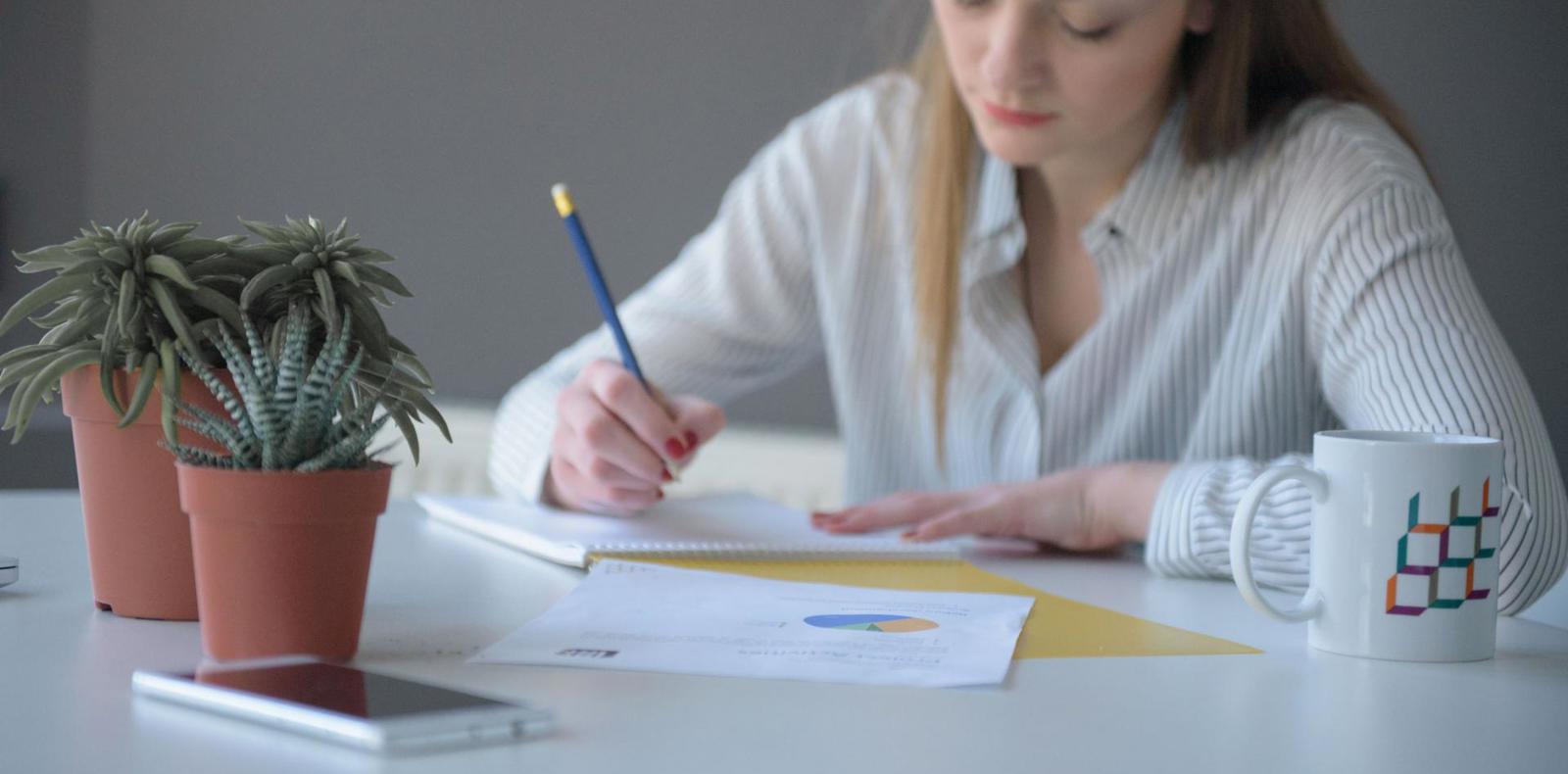 A woman writing something on a paper.