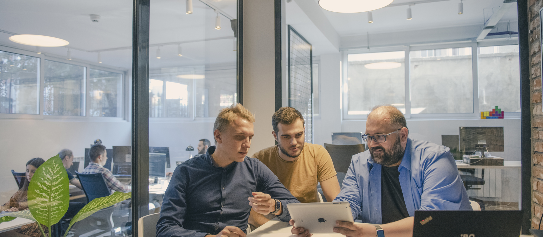 A team of professionals collaborating at a desk in an office, brainstorming and working together to achieve their goals.