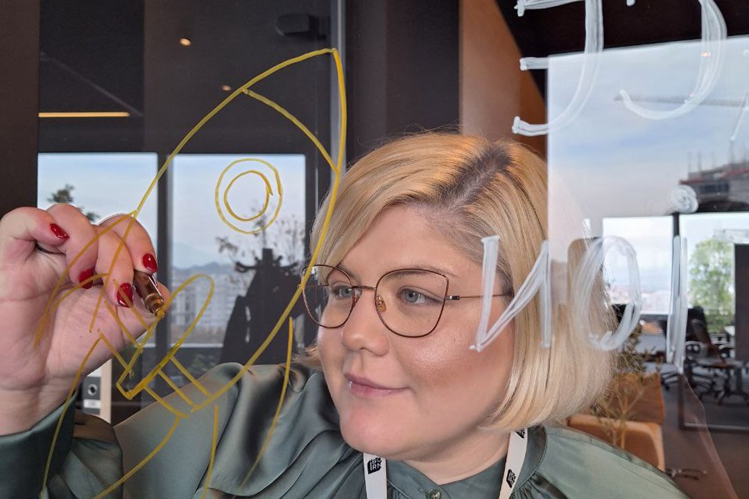 A woman writing on a glass wall, expressing her thoughts and ideas.