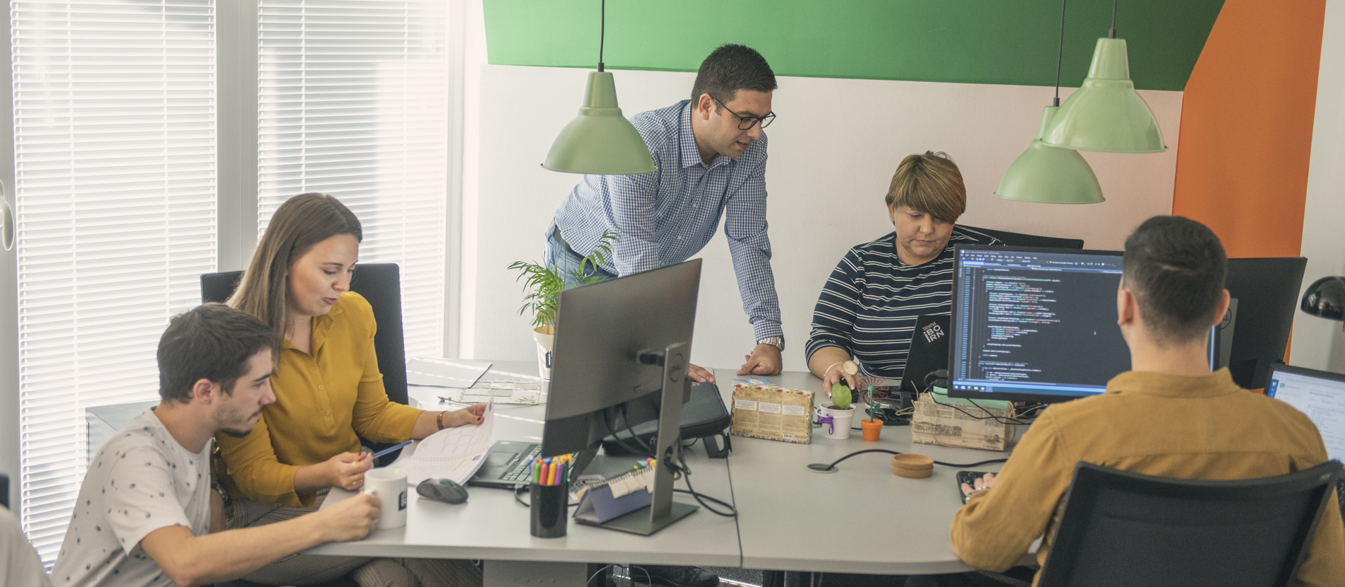 Employees focused on their work at computers in an office space.