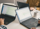 Three individuals focused on their laptops, working diligently at a table in a professional setting