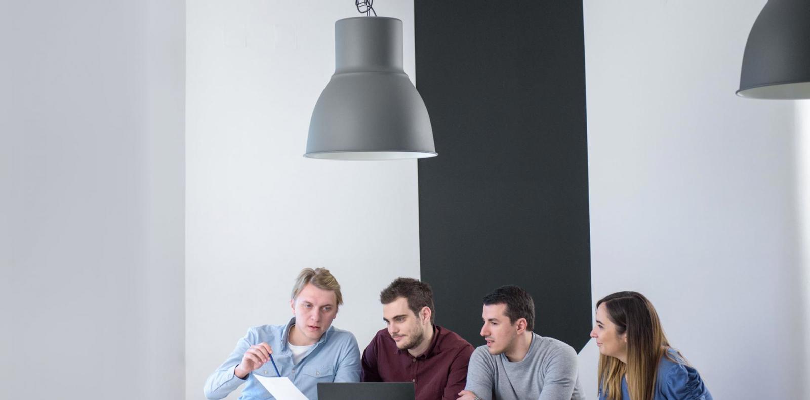 Group of software engineers working together in a bright office environment.