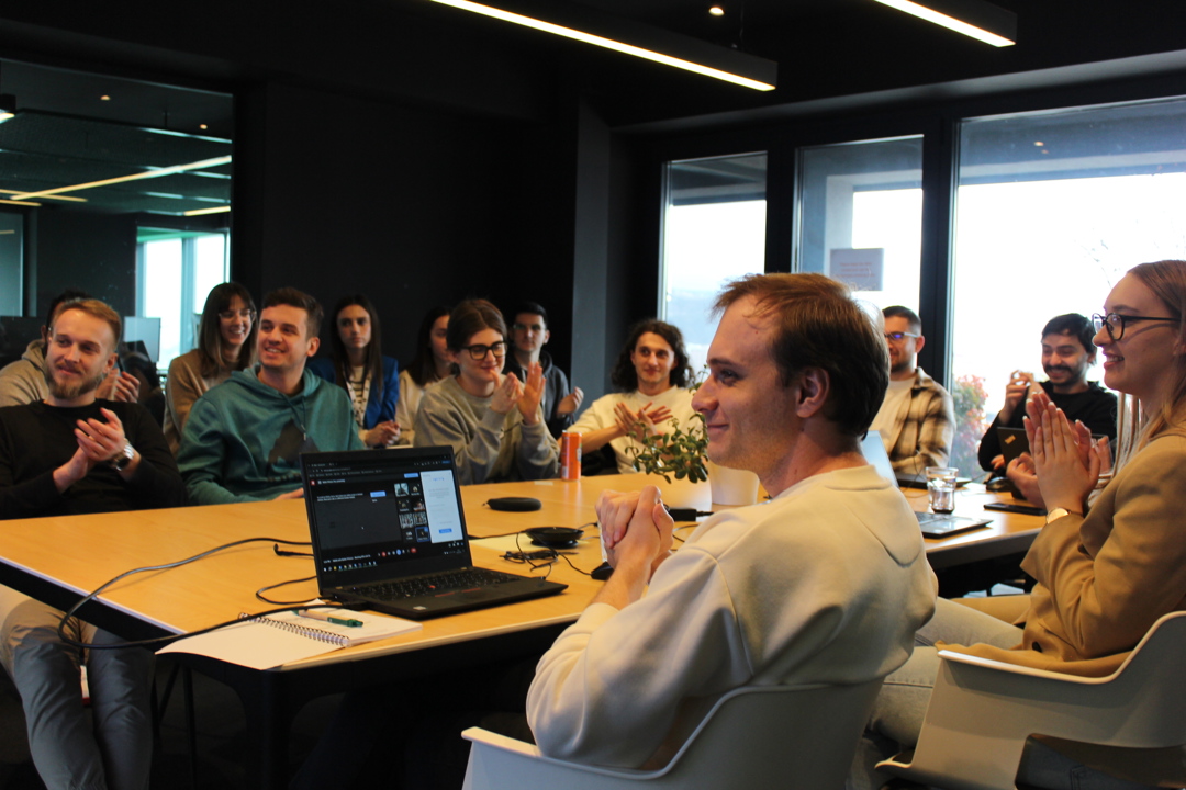 People smiling and applauding while attending a knowledge sharing session