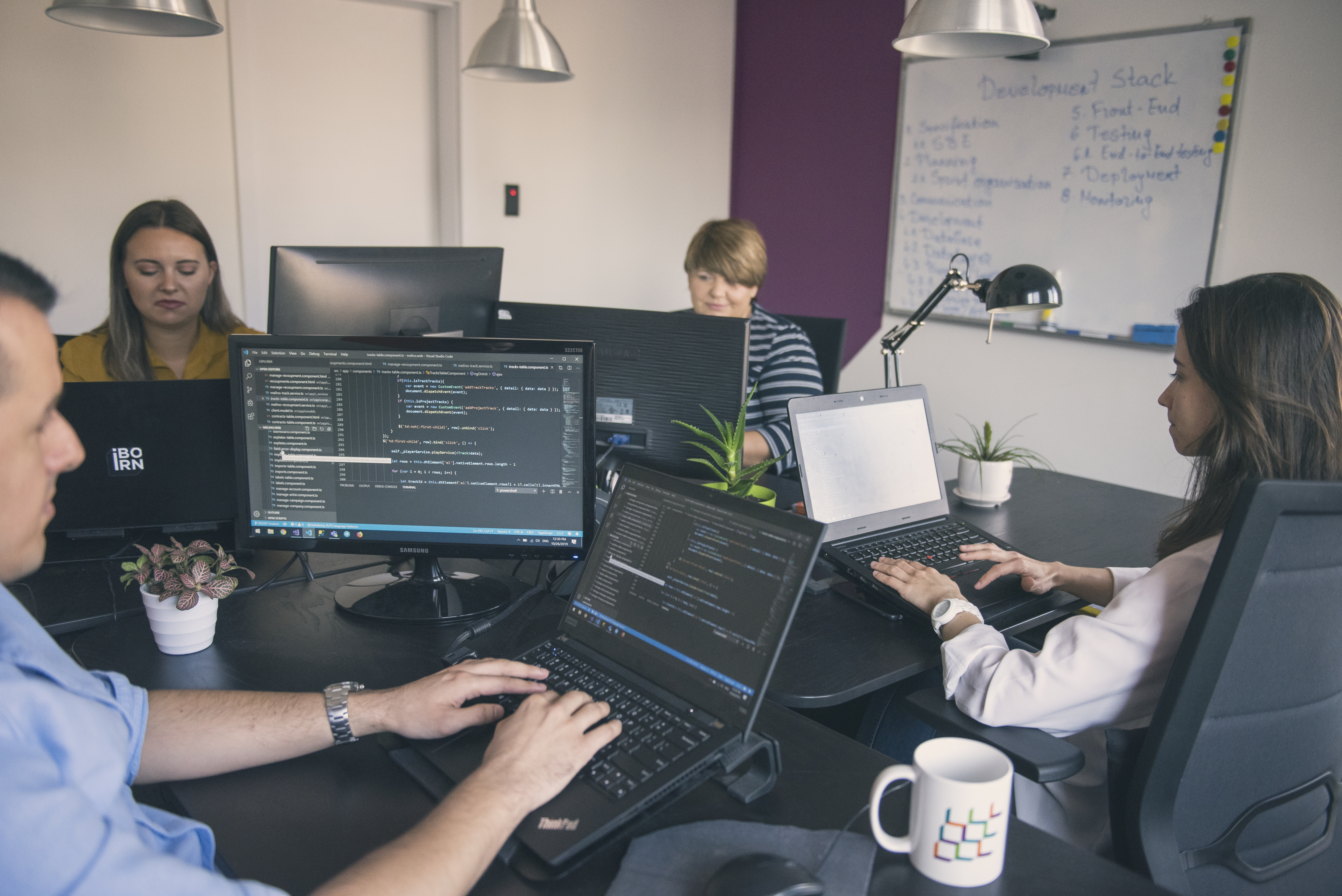 A  team of professionals diligently working on computers in a modern office setting.