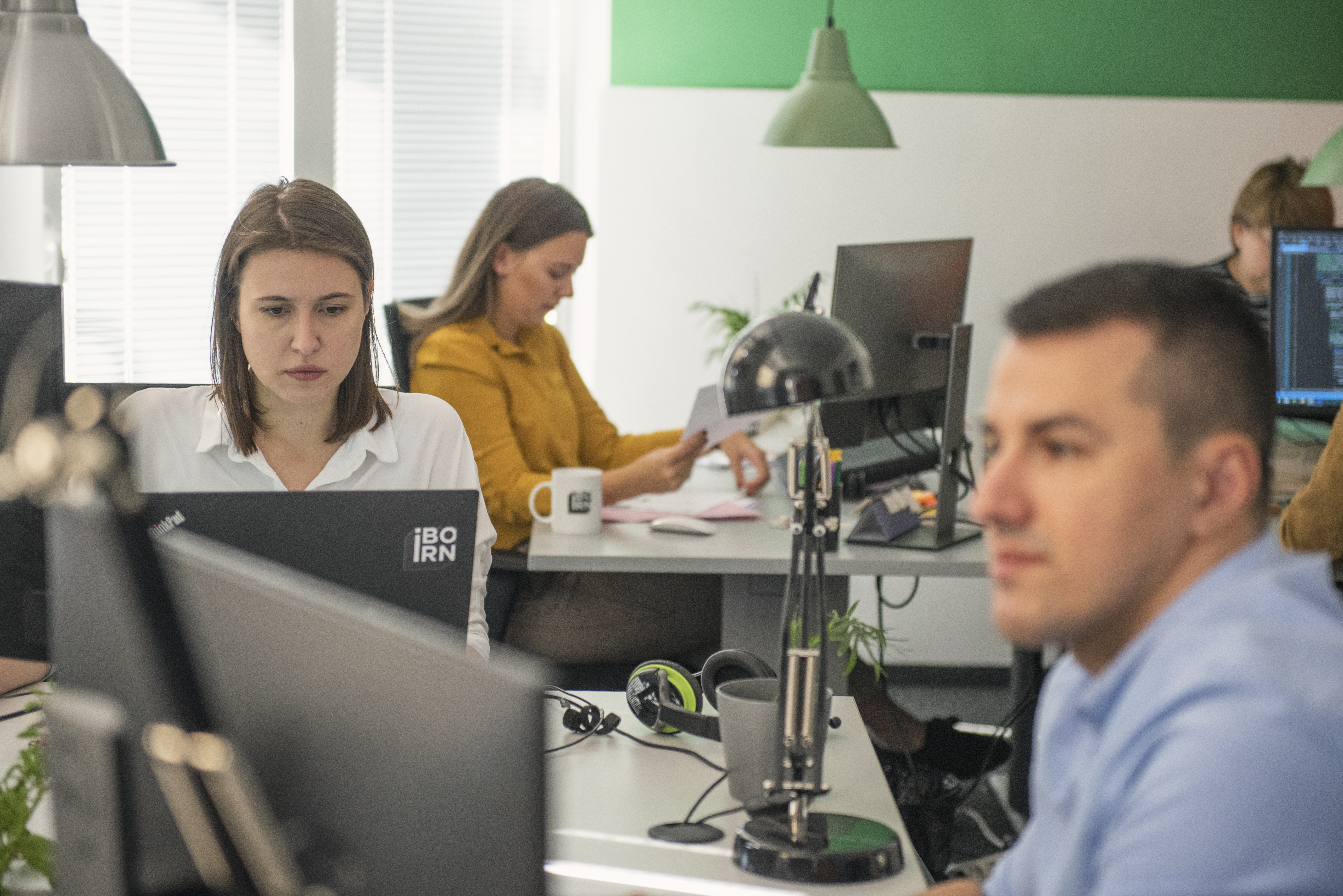 Software engineers working at their desks focused on computers and monitors. 