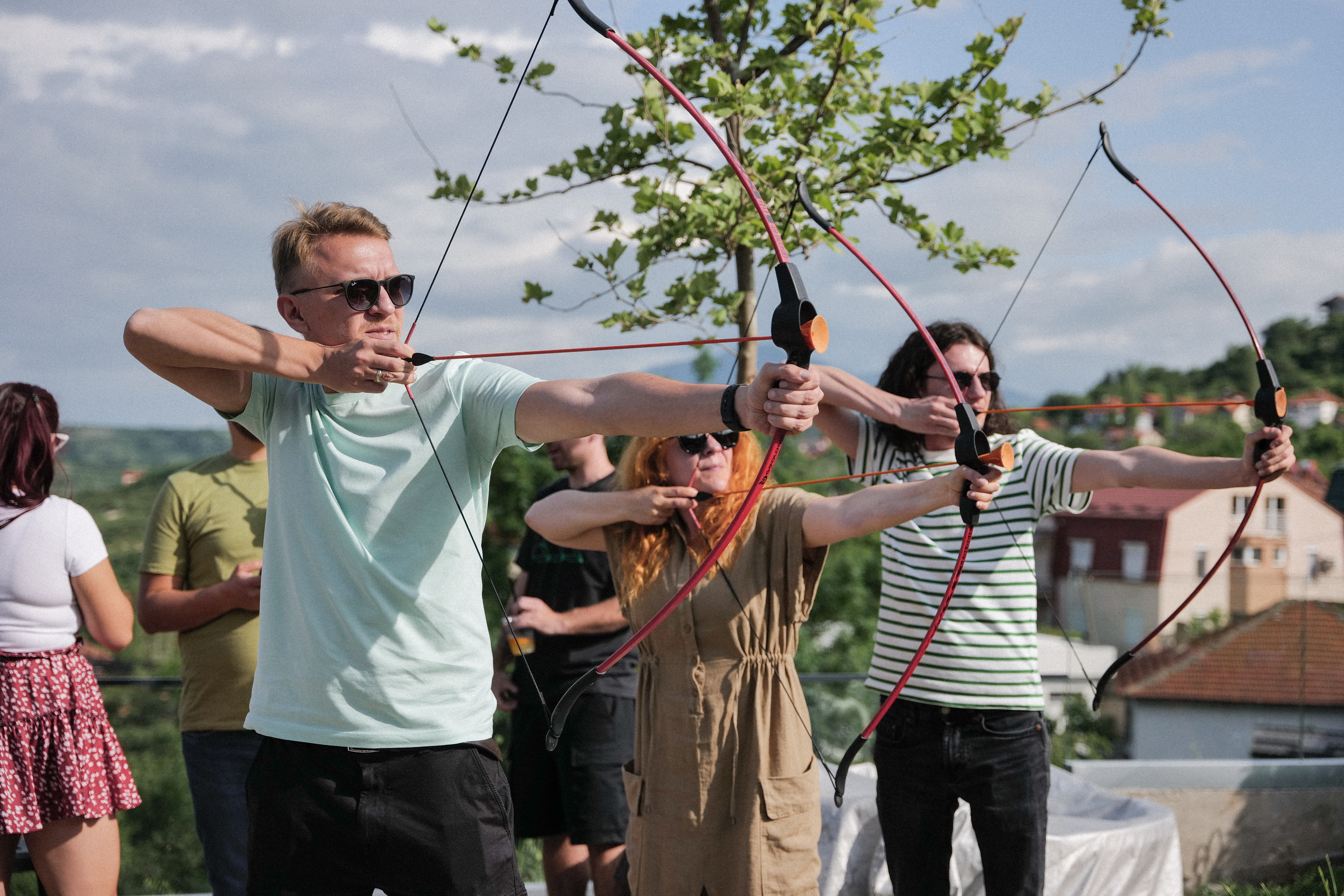 A group of people practicing archery with bow and arrow during a teambuilding. 