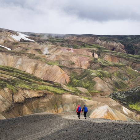 Two hikers ascending a snowy Icelandic mountain.