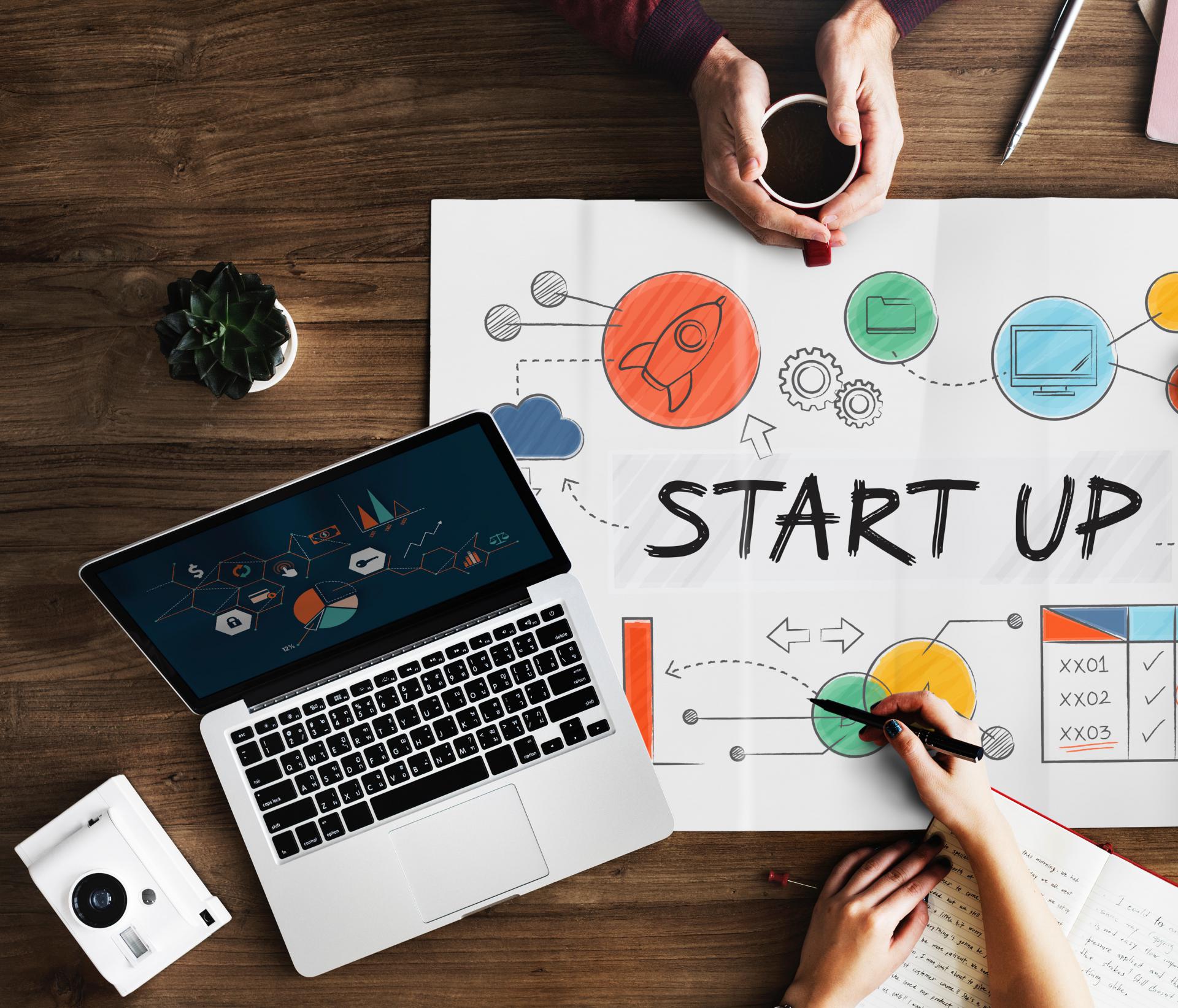 A startup concept on paper with a laptop and coffee, symbolizing innovation, technology, and entrepreneurship.
